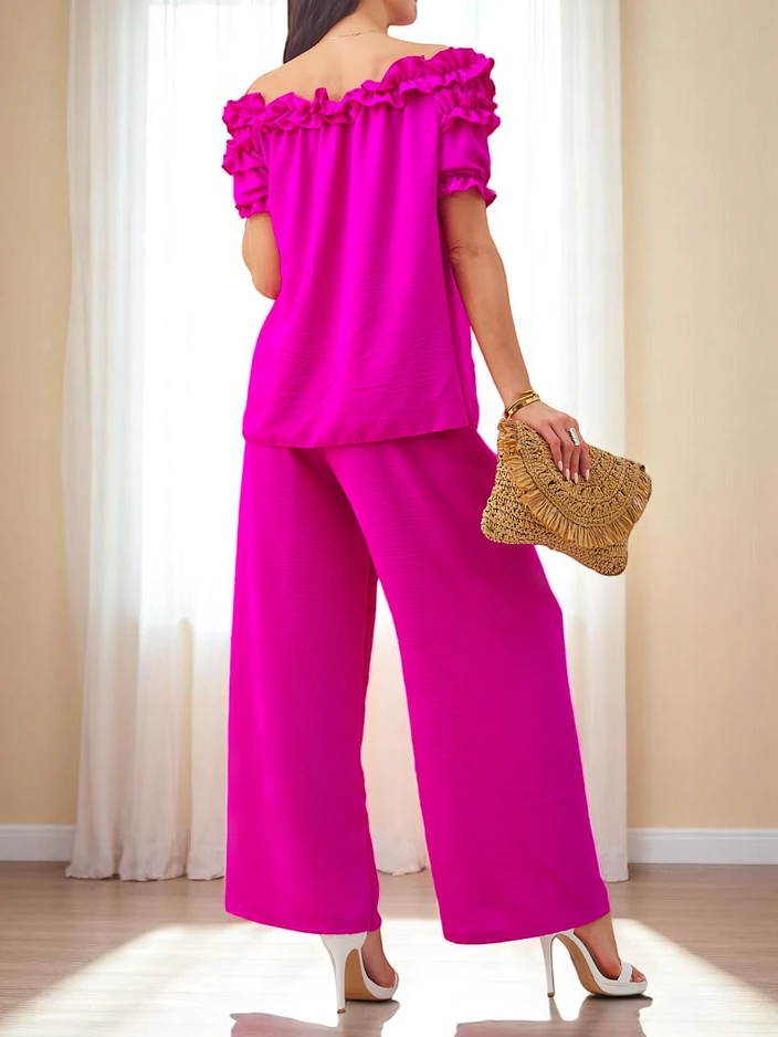 Royalfashion Sieviešu komplekts ar plecus atklājošu blūzi ar īsām piedurknēm un dekoratīvu kakla izgriezumu, kā arī platām biksēm